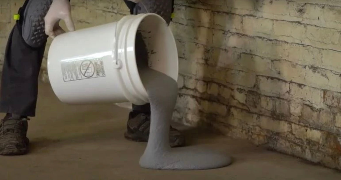 Pouring out Arctic Crete floor repair on a freezer floor